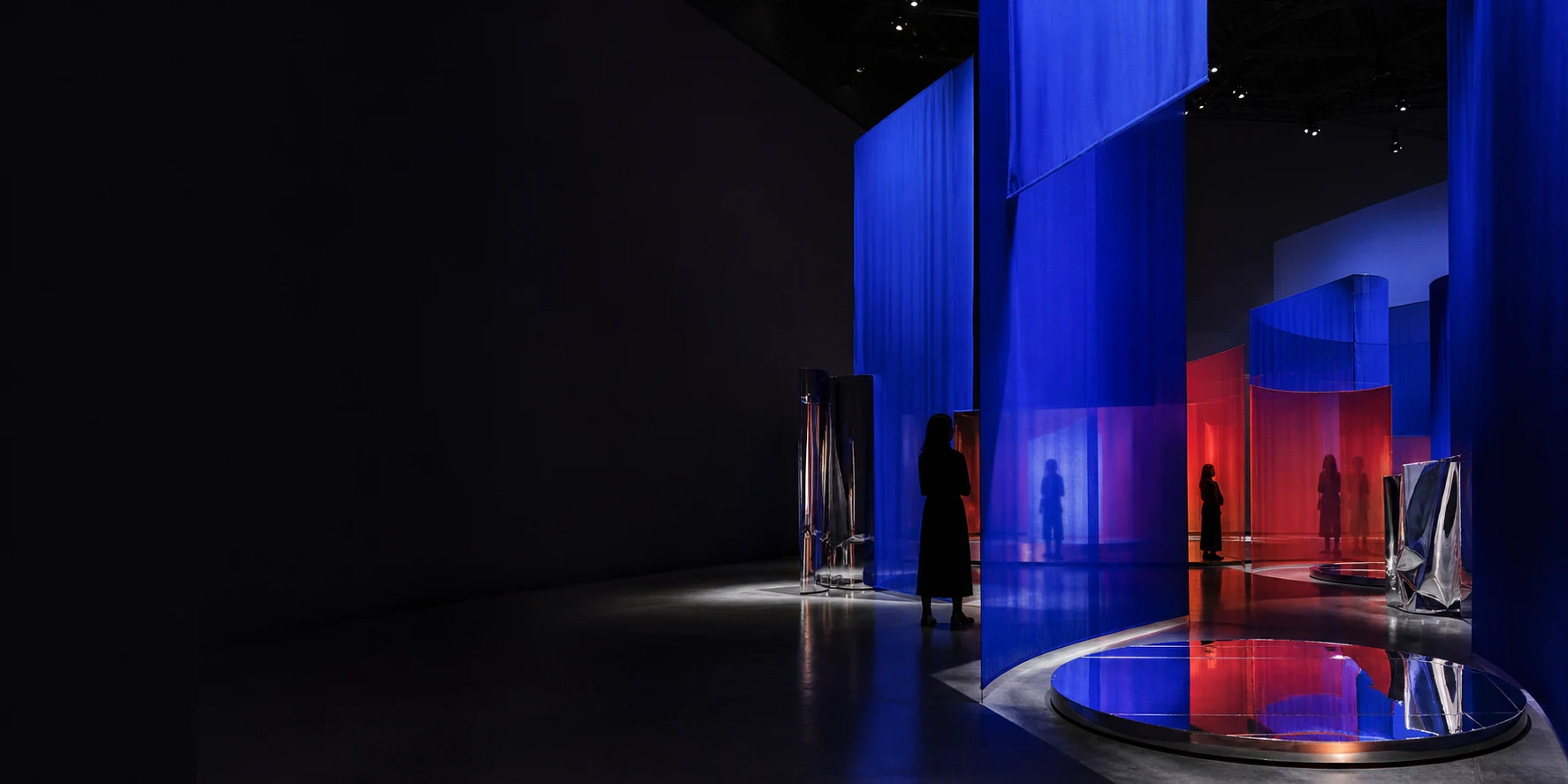 青と赤の布が揺れる現代アートの展示空間